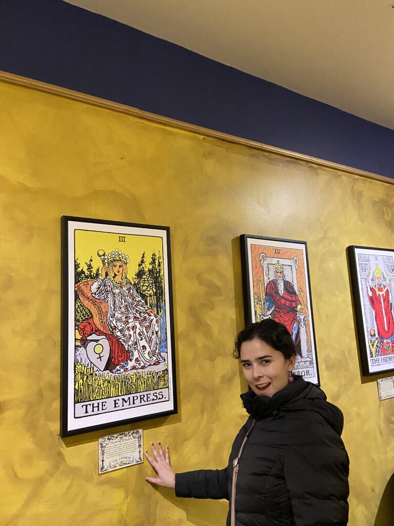 girl standing in front of an image of the Empress tarot card